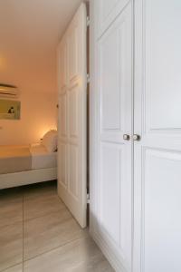 białe drzwi w sypialni z łóżkiem w obiekcie Gelos House w mieście Ornos