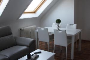 ein Wohnzimmer mit einem weißen Tisch und Stühlen in der Unterkunft Apartment mit Rheinblick in Wesseling