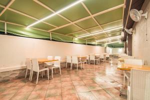 una sala da pranzo con tavoli e sedie bianche di Treebo Trend Five Elements Lonavala a Lonavala