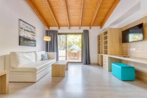 a living room with a couch and a tv at Bahía de Alcudia Hotel & Spa in Port d'Alcudia