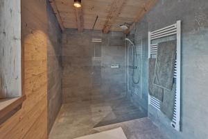 uma casa de banho com um chuveiro e uma porta de vidro em Zugspitz Lodge em Ehrwald