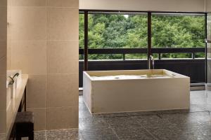 uma casa de banho com banheira e uma grande janela em Hyatt Regency Kyoto em Quioto