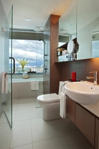 La salle de bains est pourvue d'un lavabo, de toilettes et d'une douche en verre. dans l'établissement Somerset Kuala Lumpur, à Kuala Lumpur