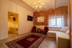 ein Wohnzimmer mit Sofa und Ziegelwand in der Unterkunft Apartament Ultra Central in Sighişoara