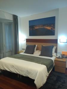 a bedroom with a large bed and a large window at Hostal San Sebastian Centro in San Sebastián