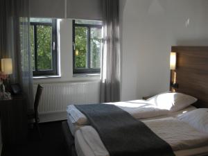 a hotel room with two beds and two windows at Hotel garni Anger 5 in Bad Frankenhausen