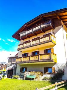 un edificio con balconi in legno sul lato di Appartamento Vista Dolomiti by GoNewLocation a Moena