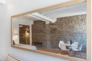 a mirror reflecting a dining room with a table and chairs at Campo De' Fiori Apartment - Charme Homes in Rome