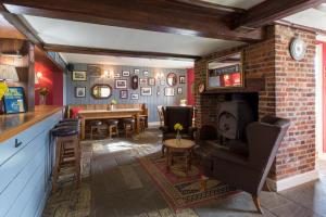 a living room with a fireplace and a table and chairs at The Plough in Wangford