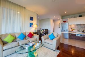 uma sala de estar com um sofá e uma mesa de vidro em Kata gardens penthouse seaview with rooftop pool 8C em Praia de Kata