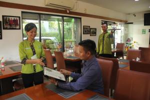 un hombre sentado en una mesa en un restaurante con una mujer en Hotel Grand Karawang Indah, en Karawang