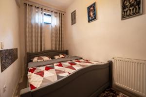 ein Schlafzimmer mit einem Bett mit einer Decke darauf in der Unterkunft Apartament Ultra Central in Sighişoara