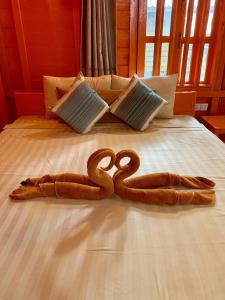 um par de cobras numa cama em The Wavy Sailor Bungalow's em Koh Rong Island