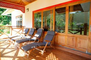 a row of chairs sitting on a porch at JMS Ventures in La Digue