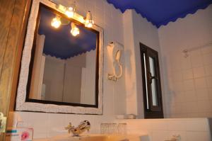 a bathroom with a mirror and a sink at Apartamentos Turisticos Doña Maria La Brava in Plasencia