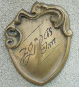 Un cuore d'ottone con una scritta su un muro di Vila Zoppas Inn a Sînnicolau Mare