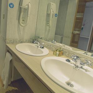 
a bathroom with two sinks and a mirror at Hotel la Muñequilla in Miraflores de la Sierra
