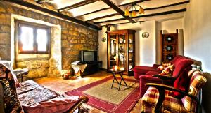 a living room with a red couch and a tv at Masia Manonelles in Biosca