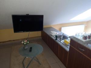 a living room with a tv and a table with a table sidx sidx sidx at Katica Vendégház in Békéscsaba