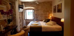 1 dormitorio con 1 cama en una habitación con una pared de piedra en San Teodoro, en Korčula