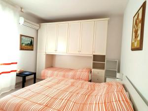 two beds in a bedroom with white cabinets at La Mandronia B&B in Alghero