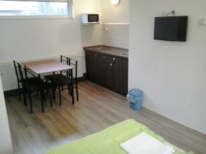 een kleine kamer met een tafel en een keuken bij Katica Vendégház in Békéscsaba