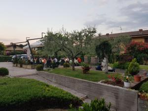 un gruppo di persone sedute in un giardino di Hotel Andreis a Cavaion Veronese