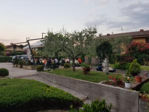 um grupo de pessoas sentadas num jardim em Hotel Andreis em Cavaion Veronese