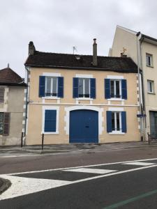 uma casa amarela e azul com uma garagem azul em Belle Place 89 Appartement em Auxerre