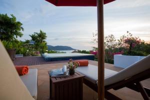 - une vue sur la terrasse dotée d'une table et d'un parasol dans l'établissement Ocean views Kata gardens penthouse 6C, à Kata Beach