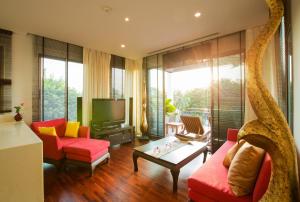 a living room with red chairs and a tv at Ocean views Kata gardens penthouse 6C in Kata Beach