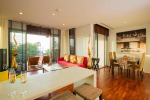 un soggiorno con divano rosso e tavolo di Ocean views Kata gardens penthouse 6C a Kata Beach