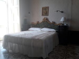 a bedroom with a large bed with a white blanket at Casato Lioy in Ripacandida