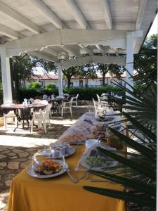 une table avec des plaques de nourriture sur elle sous un toit blanc dans l'établissement Corallo Country House, à Noci