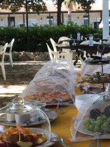 une table avec des assiettes de nourriture dans l'établissement Corallo Country House, à Noci