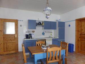 a kitchen with blue cabinets and a table and chairs at Friesenwohnung in Norden