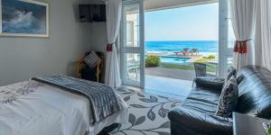 a bedroom with a bed and a view of the ocean at Ocean Breeze in Sea View