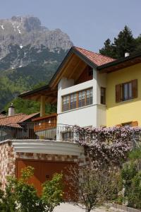 a house with a garage in front of a mountain at Villa Gardenia Molveno in Molveno