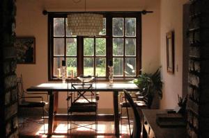 a dining room with a table and chairs and a window at Chácara das Lendas e Canções in Passa Quatro