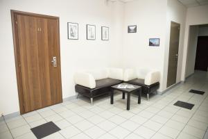 ein Wartezimmer mit weißen Stühlen und einem Tisch in der Unterkunft Europa in Uljanowsk