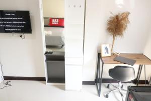 an office with a desk and a table and a chair at Baanrao Bangson in Bangkok