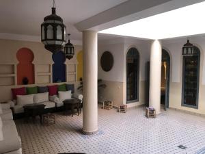 een woonkamer met een bank en tafels en zuilen bij Riad Bel Haj in Marrakesh