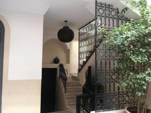a spiral staircase with a black gate in a house at Riad Bel Haj in Marrakesh