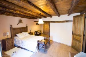 a bedroom with a bed and a wooden ceiling at La Casita de Leire in Tamajón