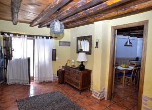 a living room with a table and a dresser with a mirror at La Casita de Leire in Tamajón