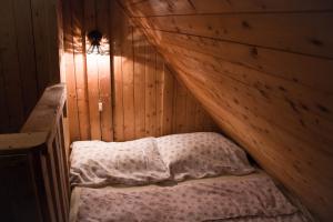 ein Schlafzimmer mit einem Bett in einer Holzwand in der Unterkunft Cottage Trenta in Bovec