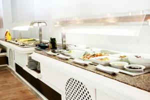 a kitchen with many bowls of food on a counter at Guya Wave Hotel in Cala Ratjada +100 photos