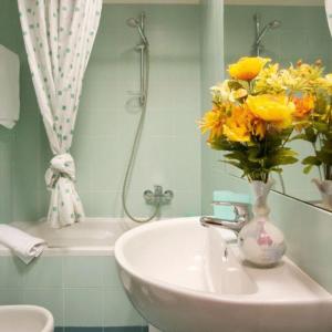 a bathroom with a vase of flowers on a sink at Residence Viserba in Milan