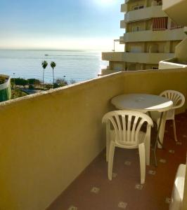 ベナルマデナにあるEstudios y Apartamentos Benal Beachの海を望むバルコニー(テーブル、椅子付)