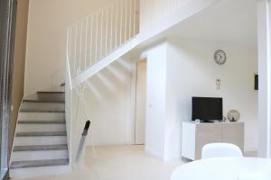 eine weiße Treppe im Wohnzimmer mit einem TV in der Unterkunft Via Magolfa - Heart of Canals in Mailand
